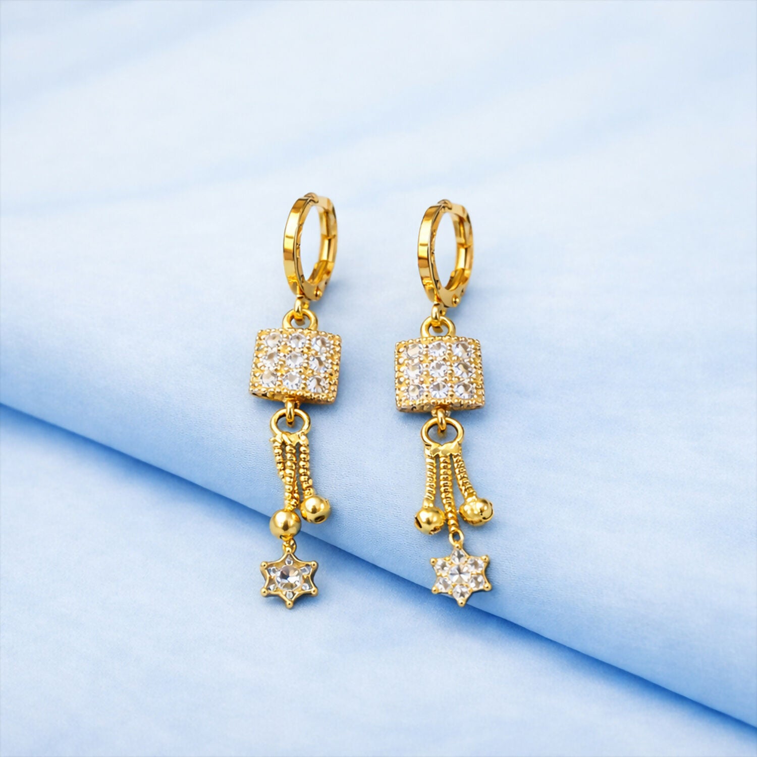 Gold finish square drop earrings with sparkling stone cube and star charm front view