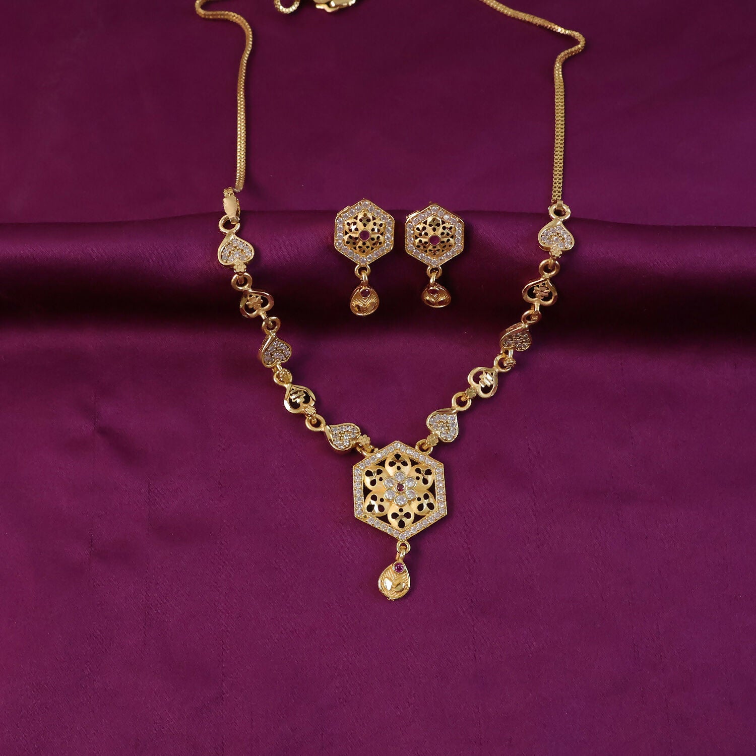 Matching earrings with gold-tone finish and intricate design