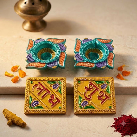 Two teal and purple lotus-shaped diyas with two yellow Shubh Labh tiles, surrounded by turmeric and red powder.