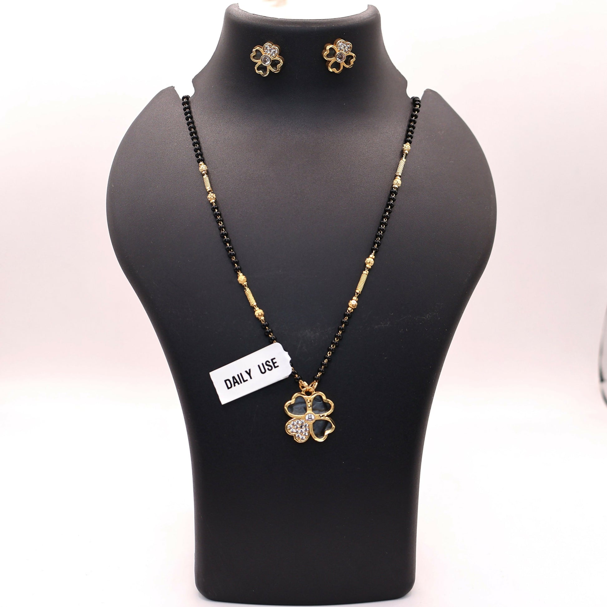 Matching floral stud earrings paired with the luck clover pendant mangalsutra