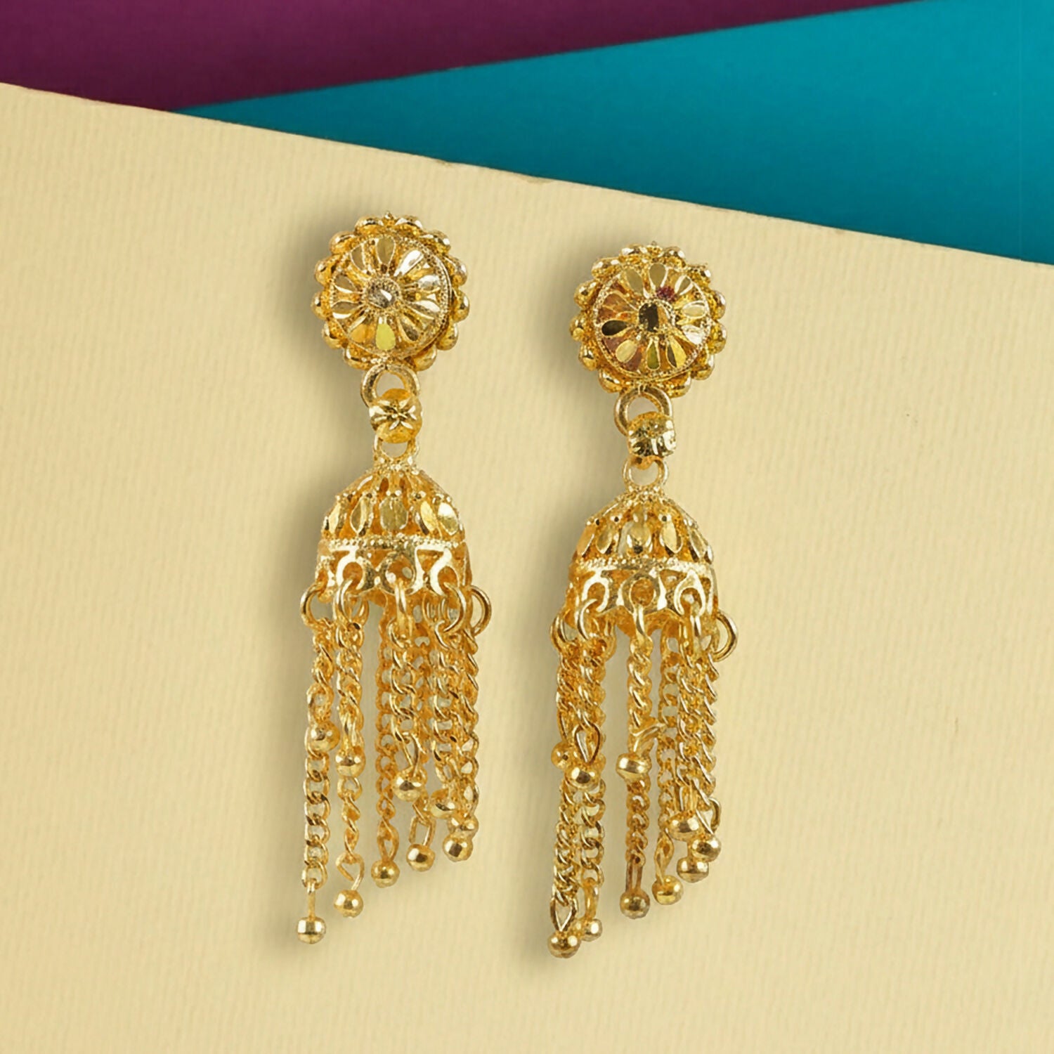 Side view of gold plated tassel jhumka earrings showcasing hanging chains