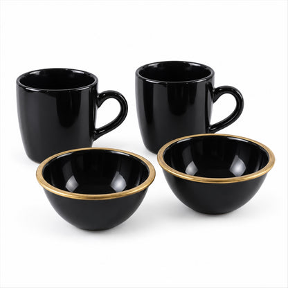 Two glossy black ceramic mugs and two matching bowls with gold rims are arranged on a white background.