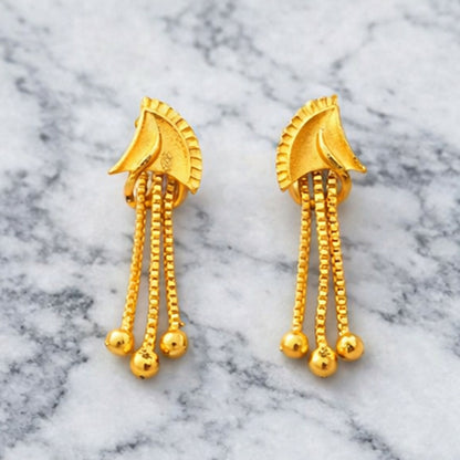Close up of golden finish and shiny stones on drop earrings