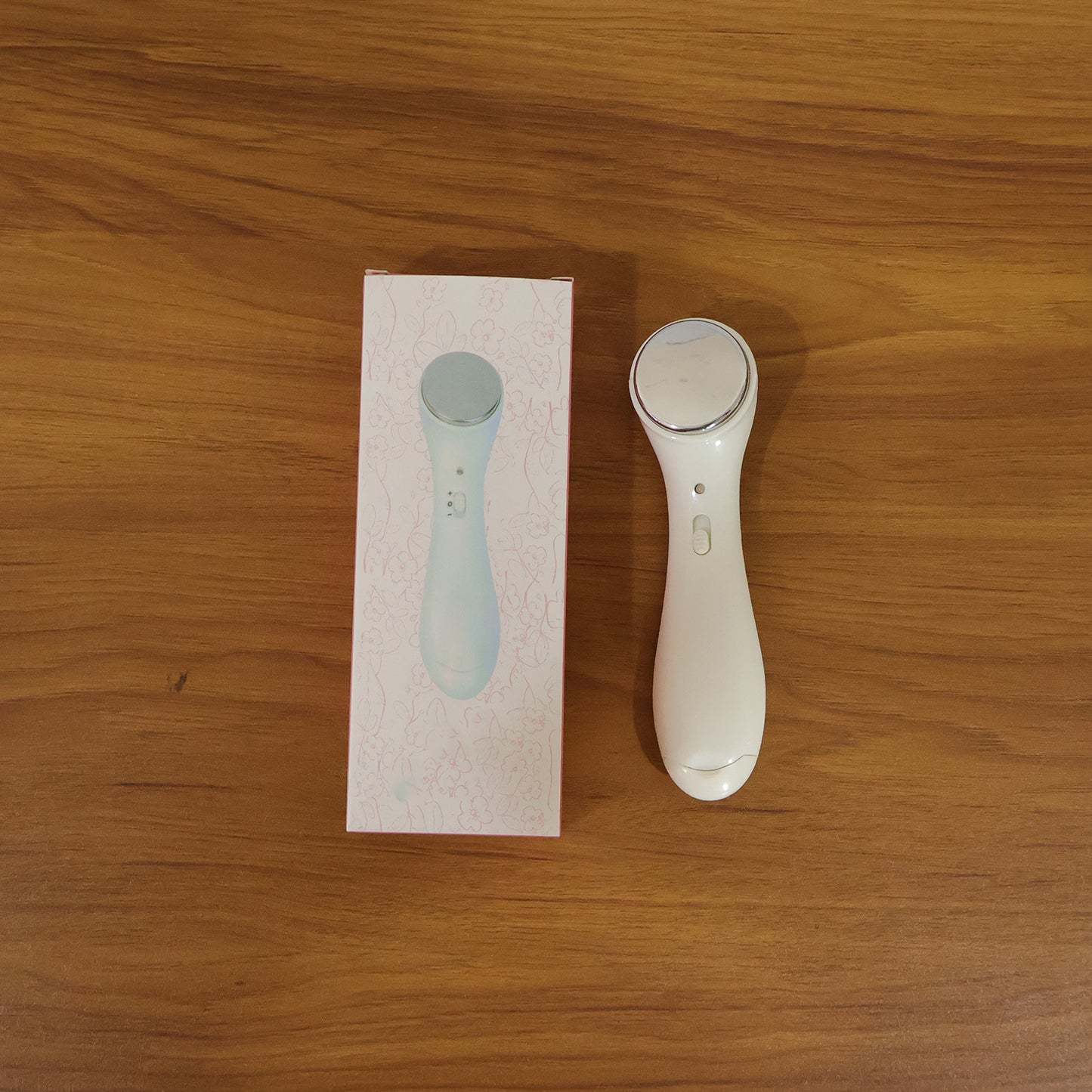 Facial massager device in use on skin