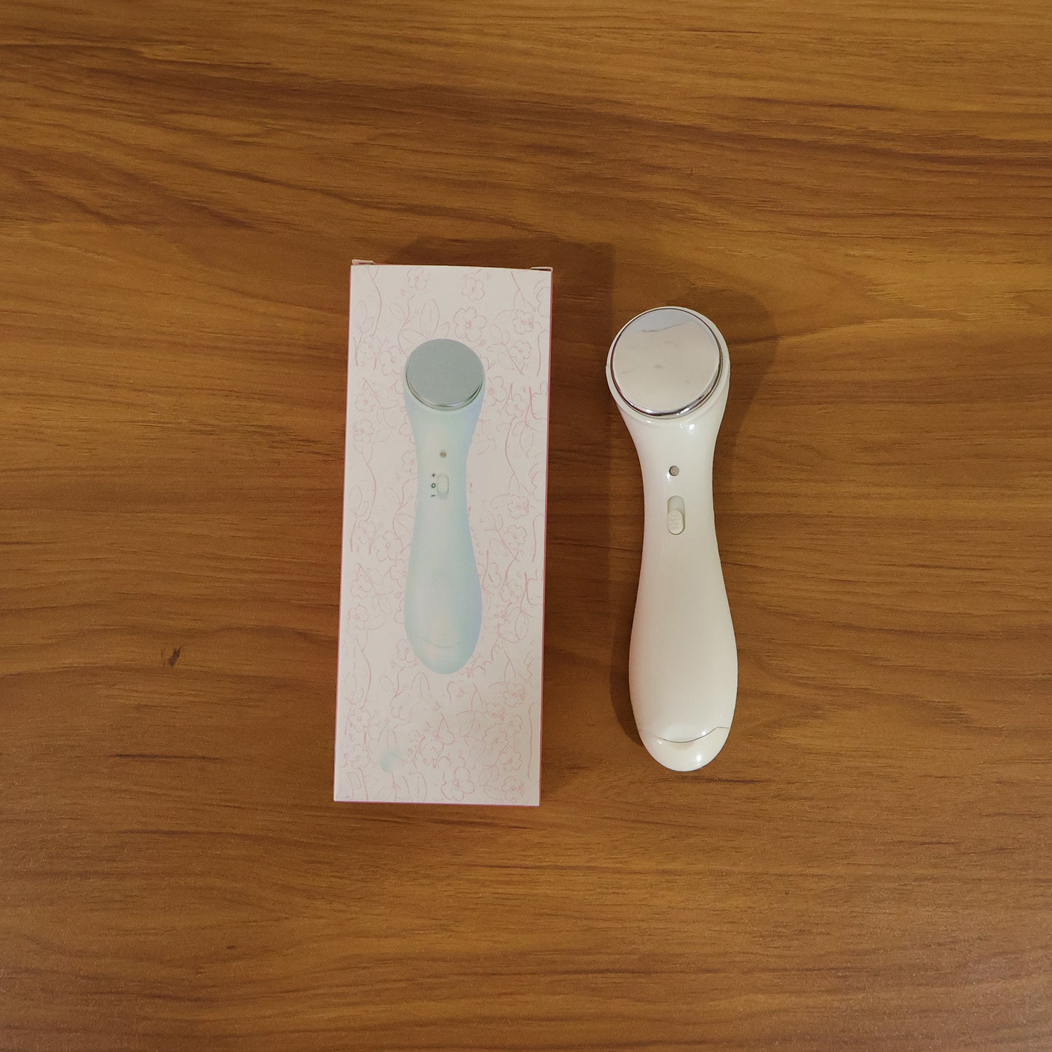 Facial massager device in use on skin