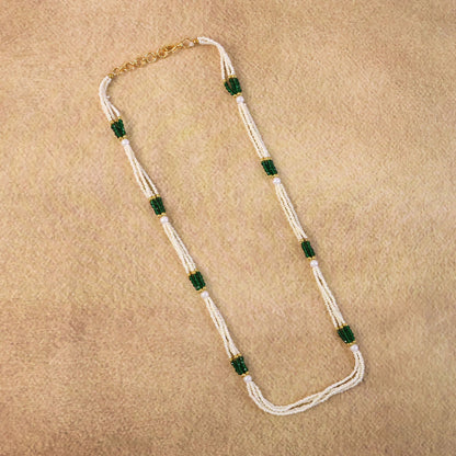 Close-up of green accent beads on pearl mala necklace with gold details