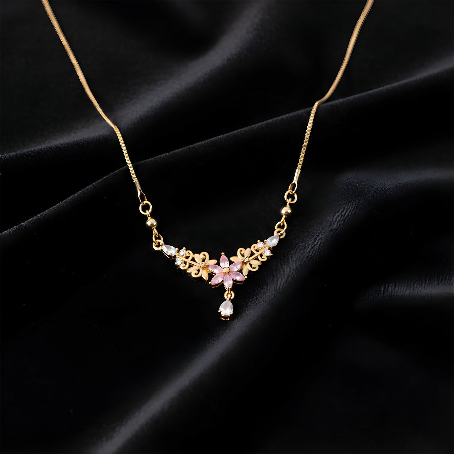 Detailed view of delicate pink floral pendant necklace with crystal drop