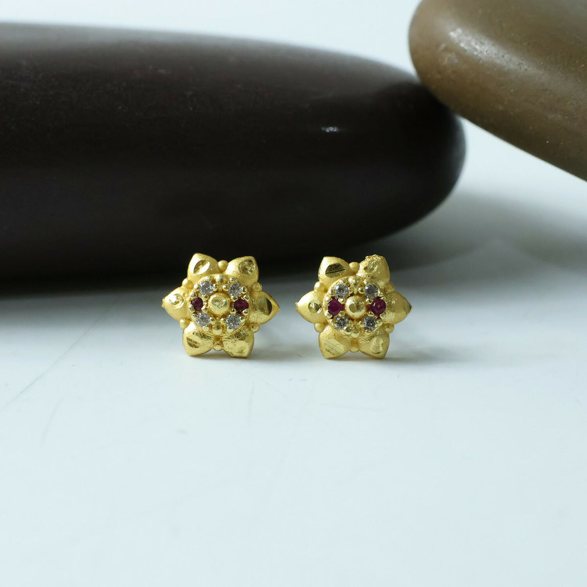 Gold stud earrings with floral design and sparkling stones in elegant finish