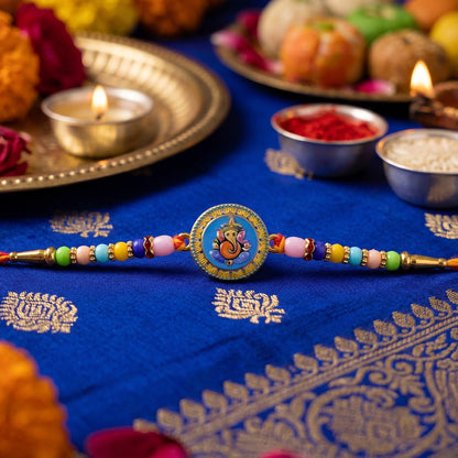 Traditional Lord Ganesha Rakhi laid out on white background