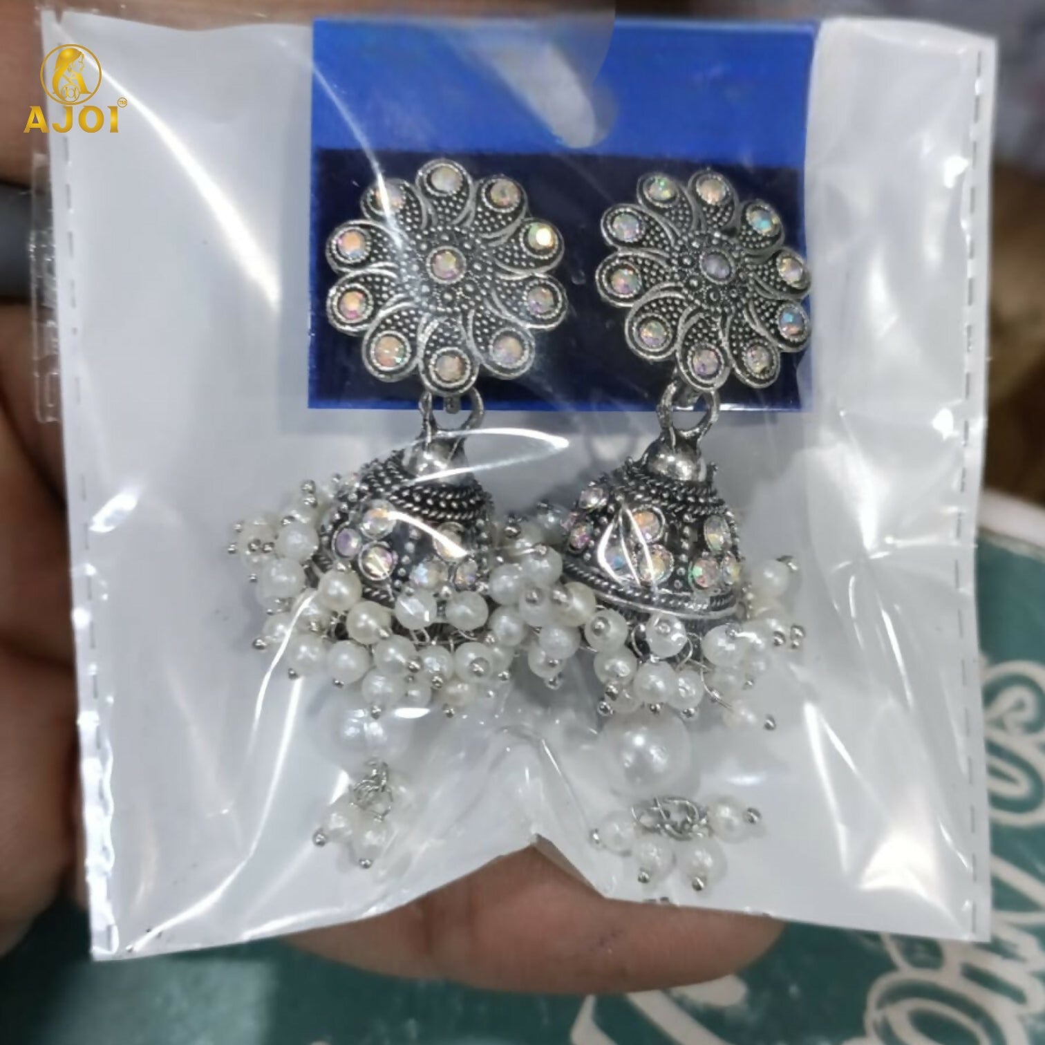Pair of oxidised silver round jhumka earrings with pearls on white background