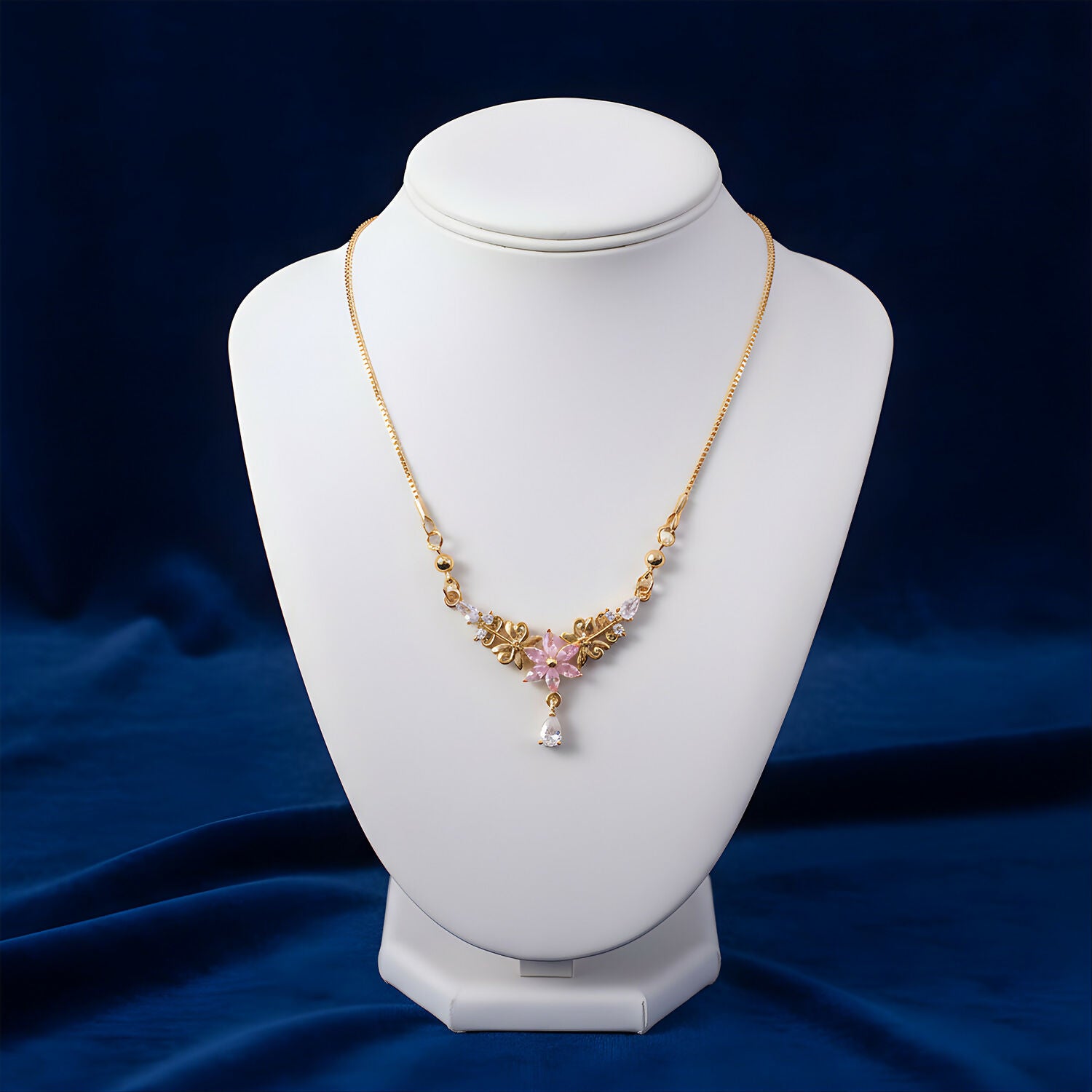 Close-up of pink floral pendant in gold finish with sparkling crystal drop necklace