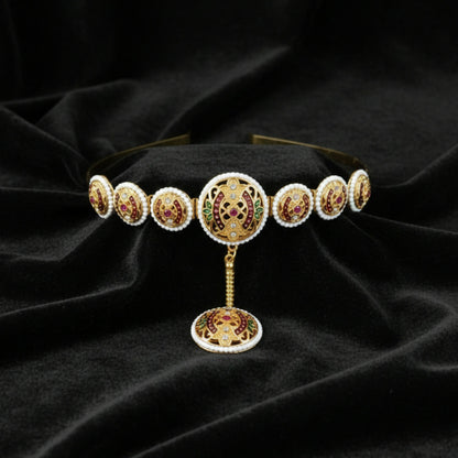 Close-up of vibrant ruby and emerald minakari stones and pearl border on Matha Patti