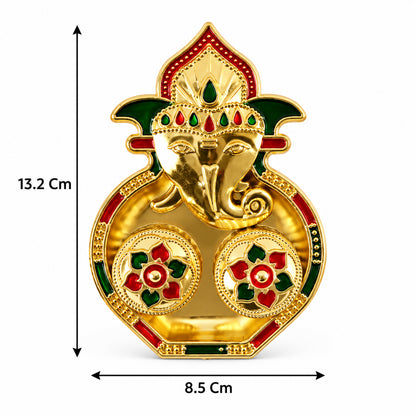 A golden Ganesha-shaped kumkum holder with red and green enamel details, showing dimensions of 13.2 cm by 8.5 cm.