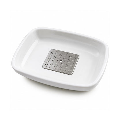 The garlic ginger grater plate in use, grating ginger over a dish