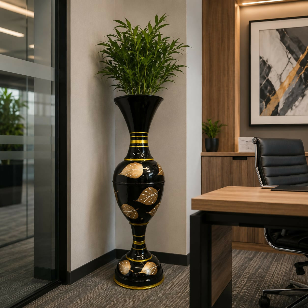 Close-up of gold leaf detailing on black metal vase