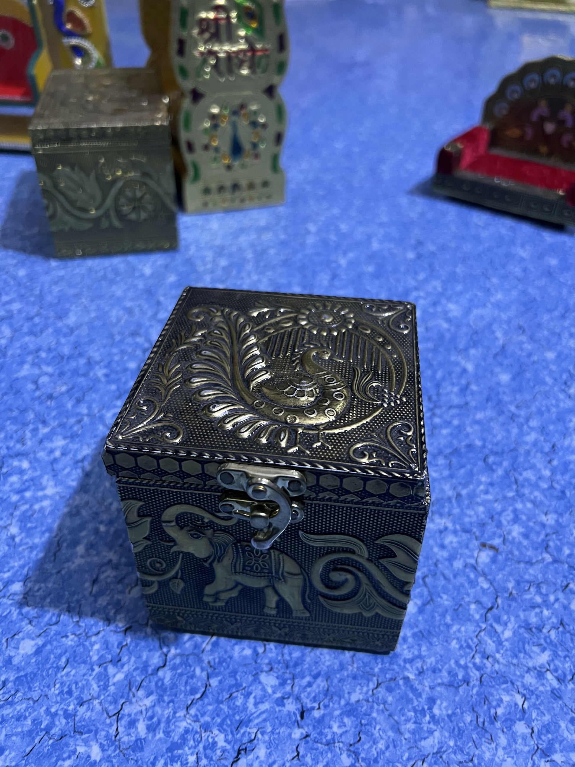 Metallic lidded jar and embossed brass box set on display