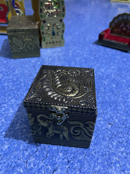 Metallic lidded jar and embossed brass box set on display