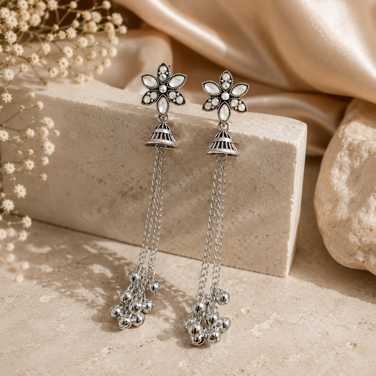 Elegant oxidised silver jhumka earrings with a detailed floral stud and long chain tassels.