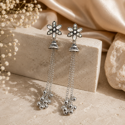 Elegant oxidised silver jhumka earrings with a detailed floral stud and long chain tassels.