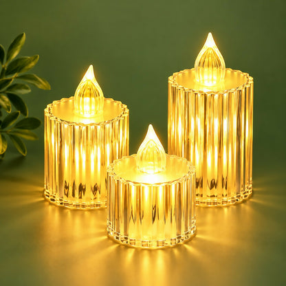 Three radiant crystal-look LED candles of different sizes on a dark green surface with a plant leaf.