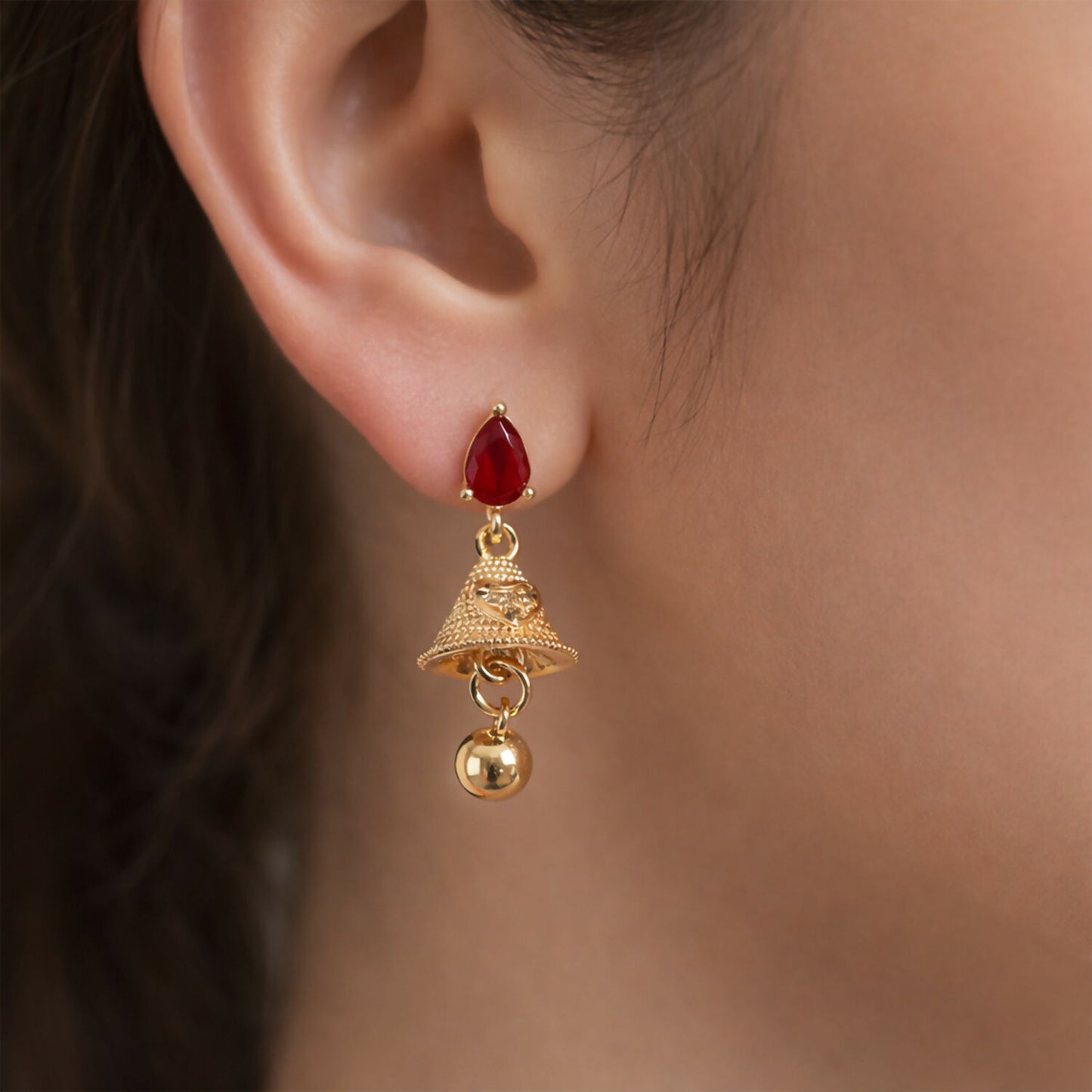 Side angle of ruby teardrop stud jhumka earrings showcasing textured gold bell