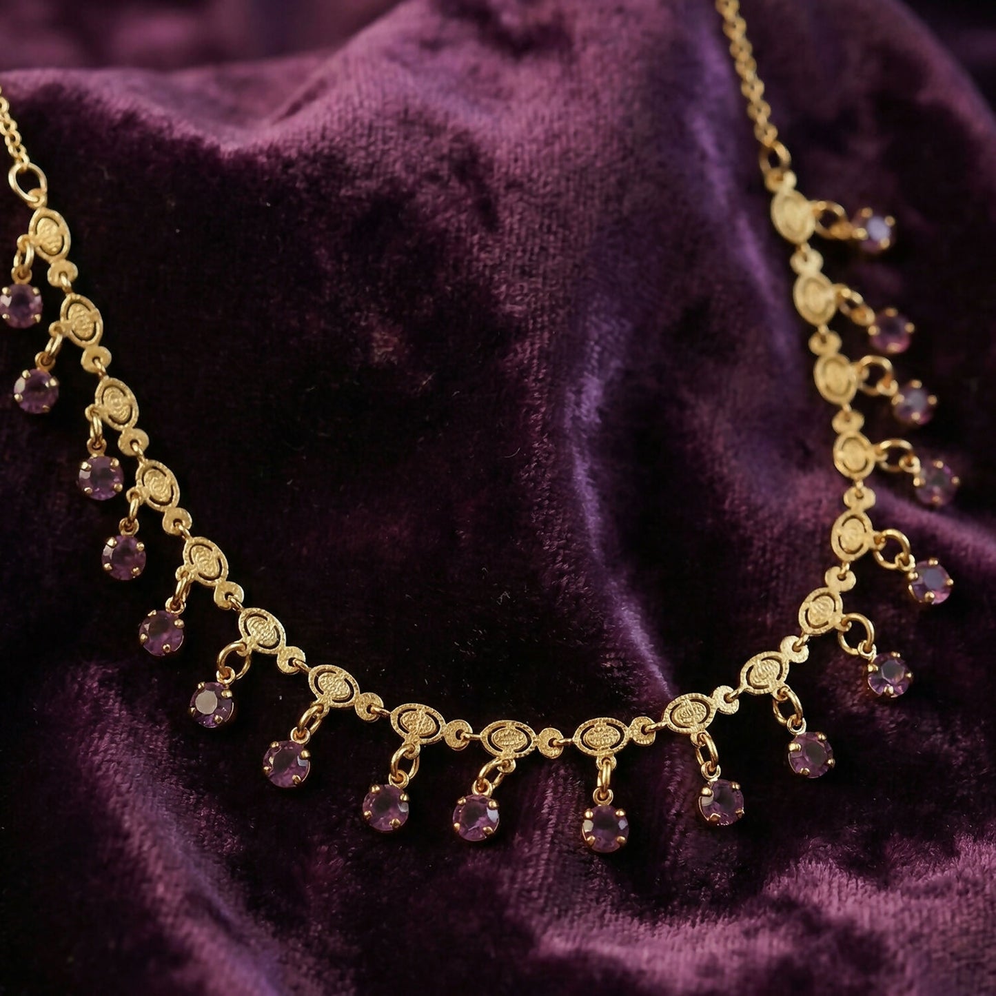 Elegant gold necklace featuring leaf motifs and red stone drops