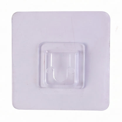 Transparent wall hook attached to a smooth surface for organization.
