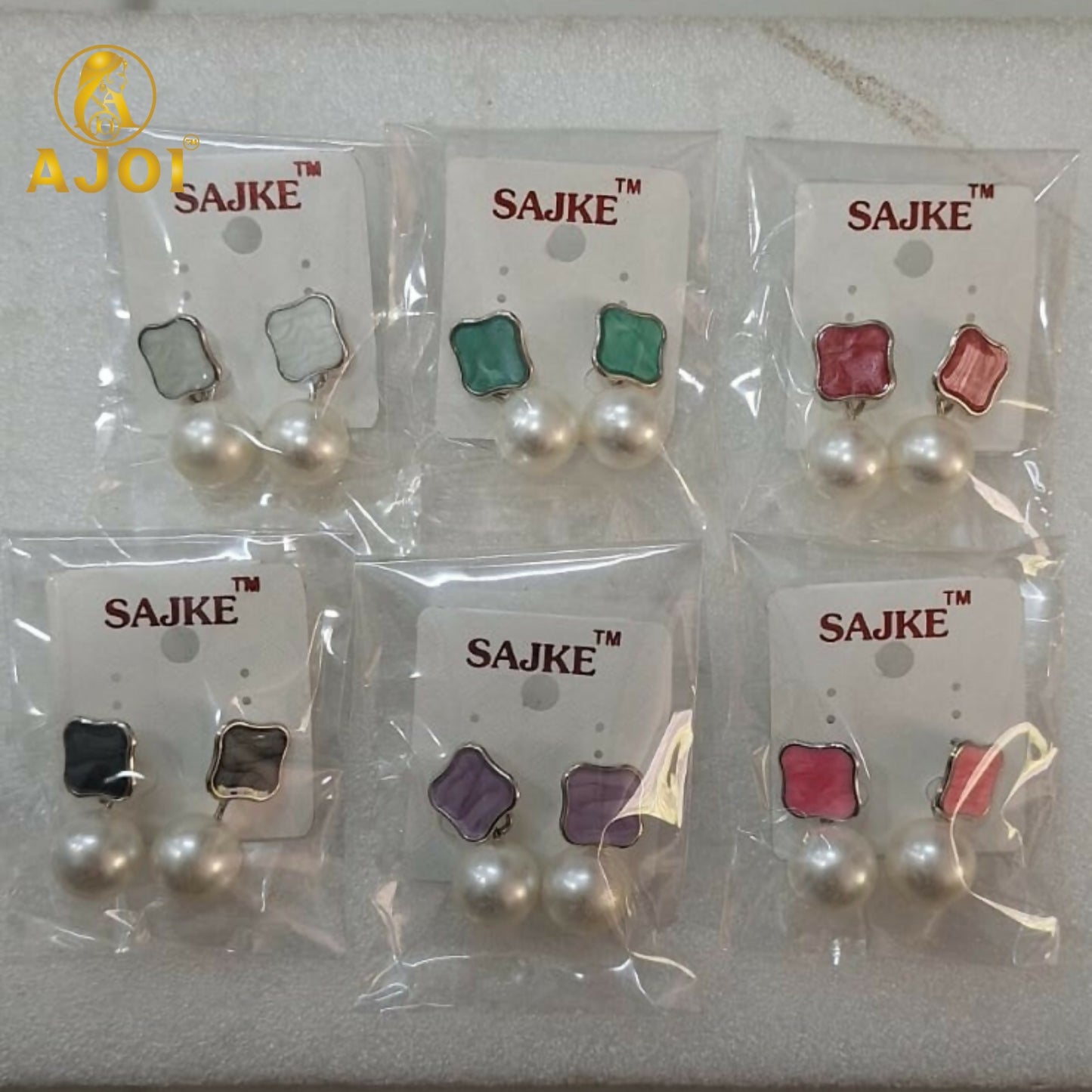 Colorful enamel stud and pearl drop earrings highlighting design details
