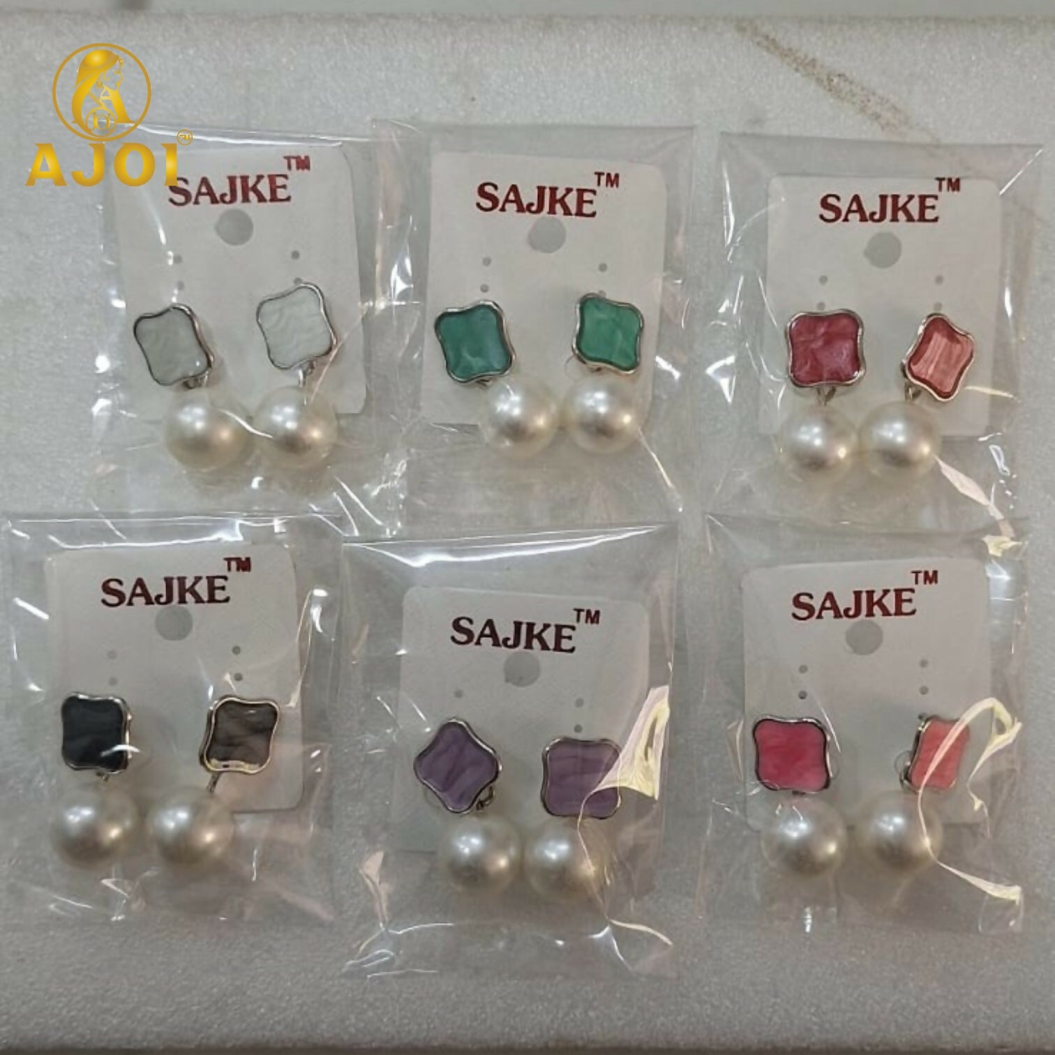 Colorful enamel stud and pearl drop earrings highlighting design details