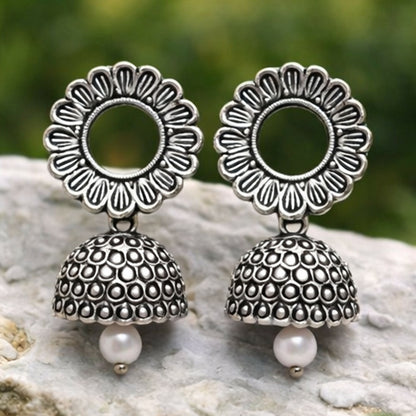Close-up of traditional oxidized silver floral jhumka earrings highlighting craftsmanship