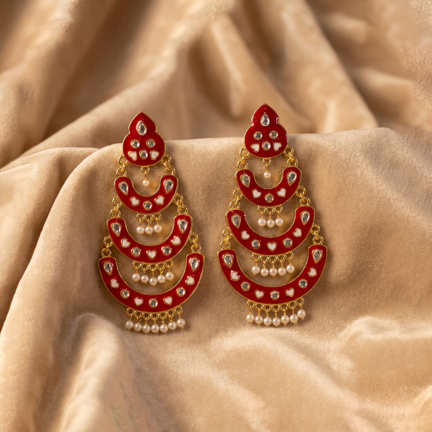 Detailed view of pearl hanging on red layered chandbali earrings