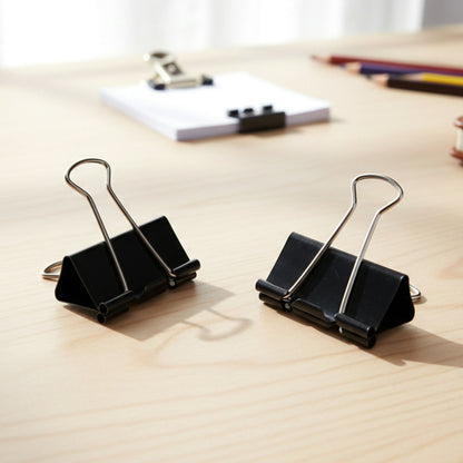 Binder clip being opened with metal arms