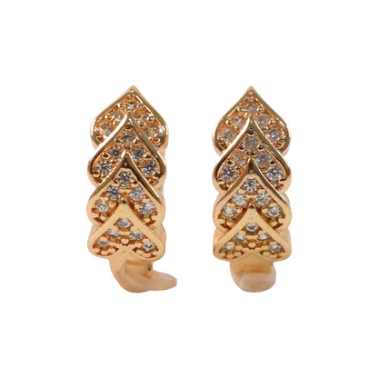 Leaf patterned gold finish earrings with sparkling stone embellishments worn on ear