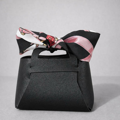Woman holding a black mini coin pouch with bow