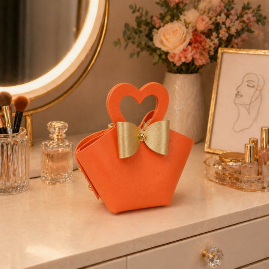 Orange mini handbag with heart-shaped handle and bow detail