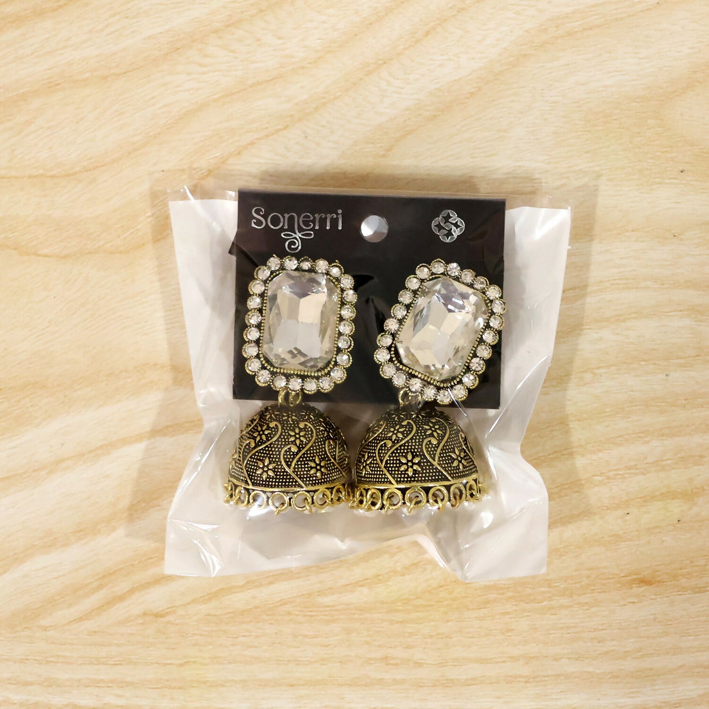 Pair of white stone antique gold jhumka earrings with pearl drops displayed