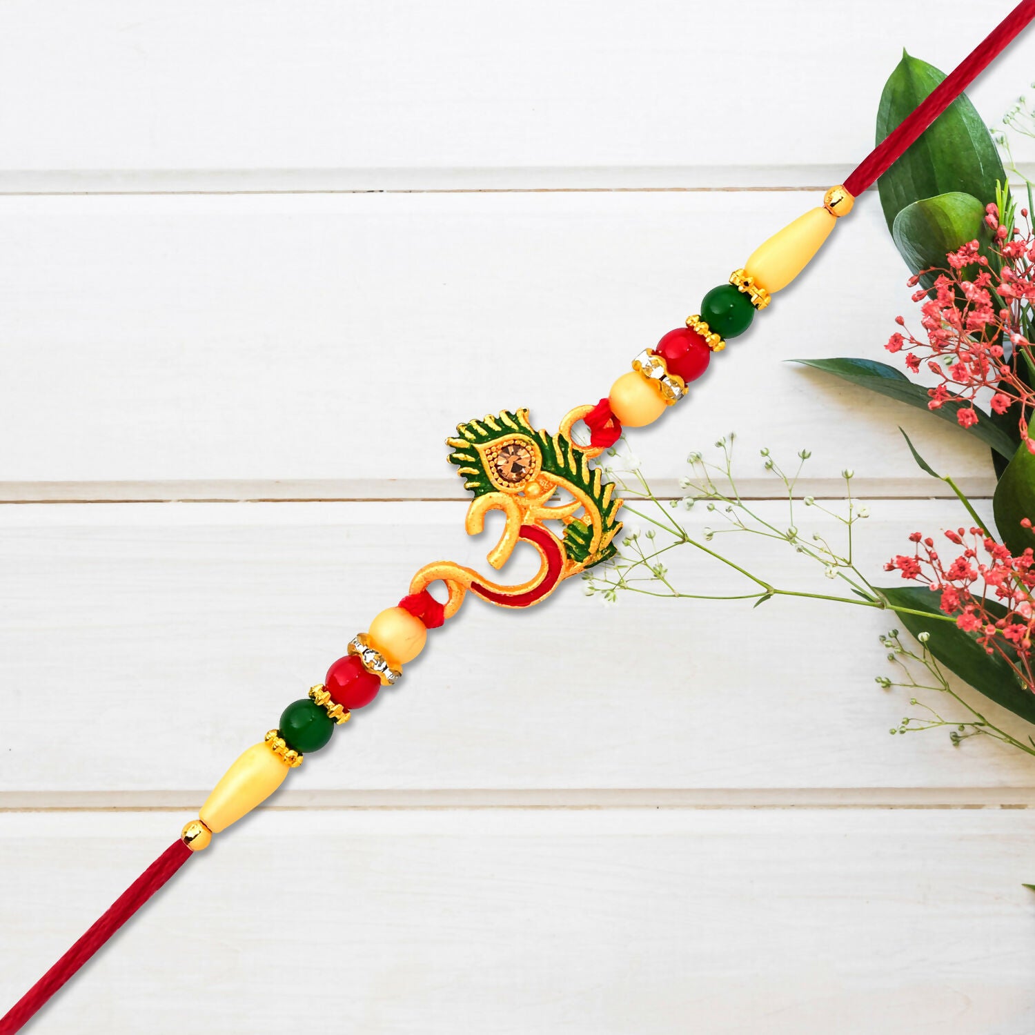 Close-up of Om symbol and peacock feather on Rakhi bracelet