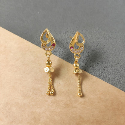 Close-up of gold polished dangler earrings showcasing diamond and ruby detailing
