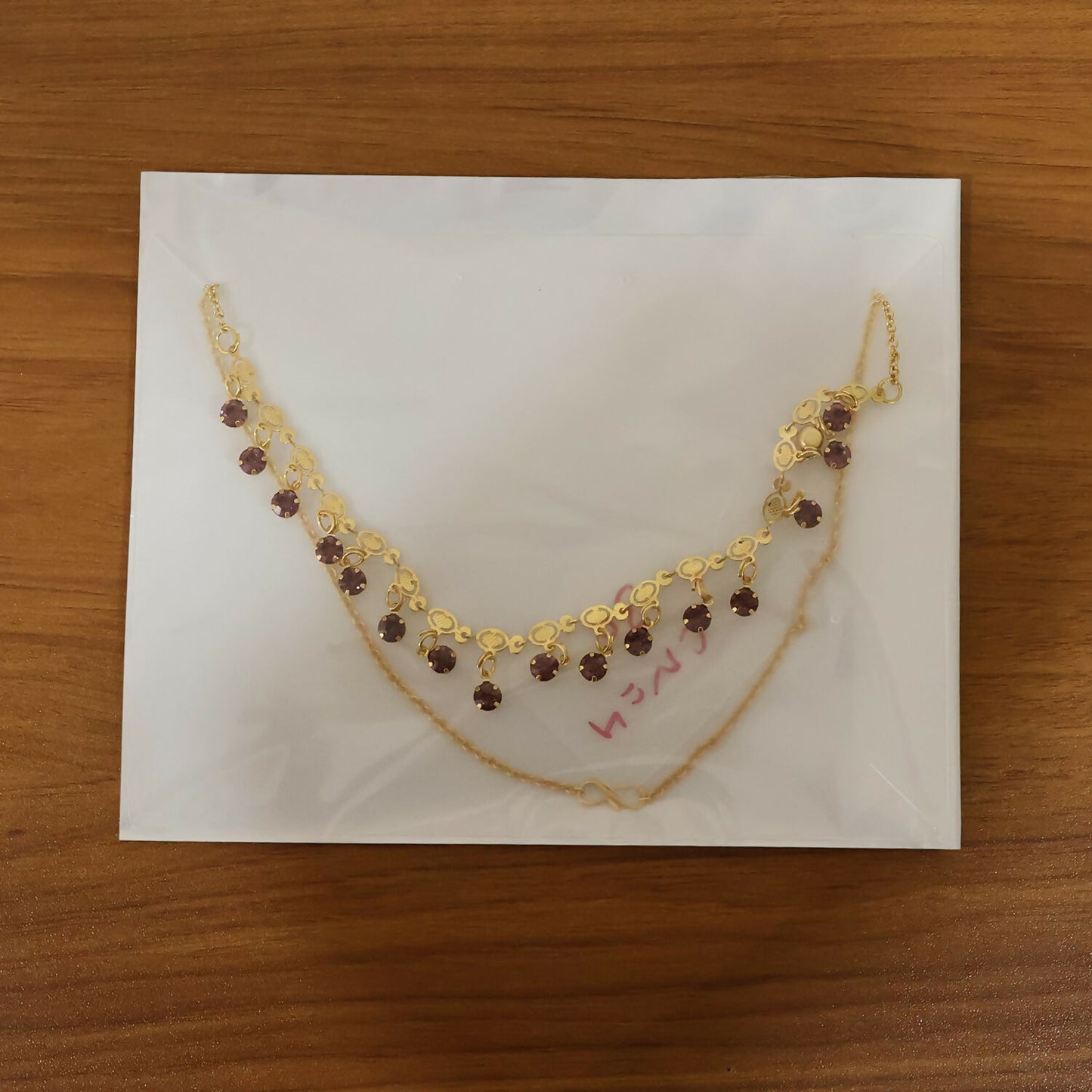 Complete view of gold plated leaf design necklace with red stones
