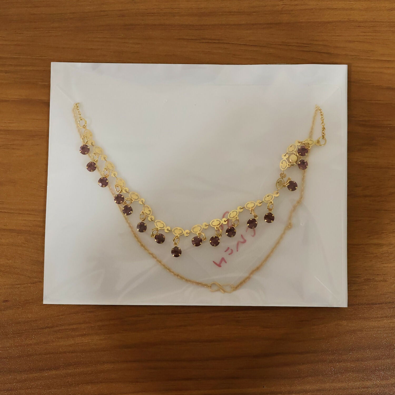 Complete view of gold plated leaf design necklace with red stones