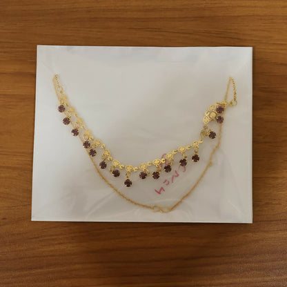 Complete view of gold plated leaf design necklace with red stones