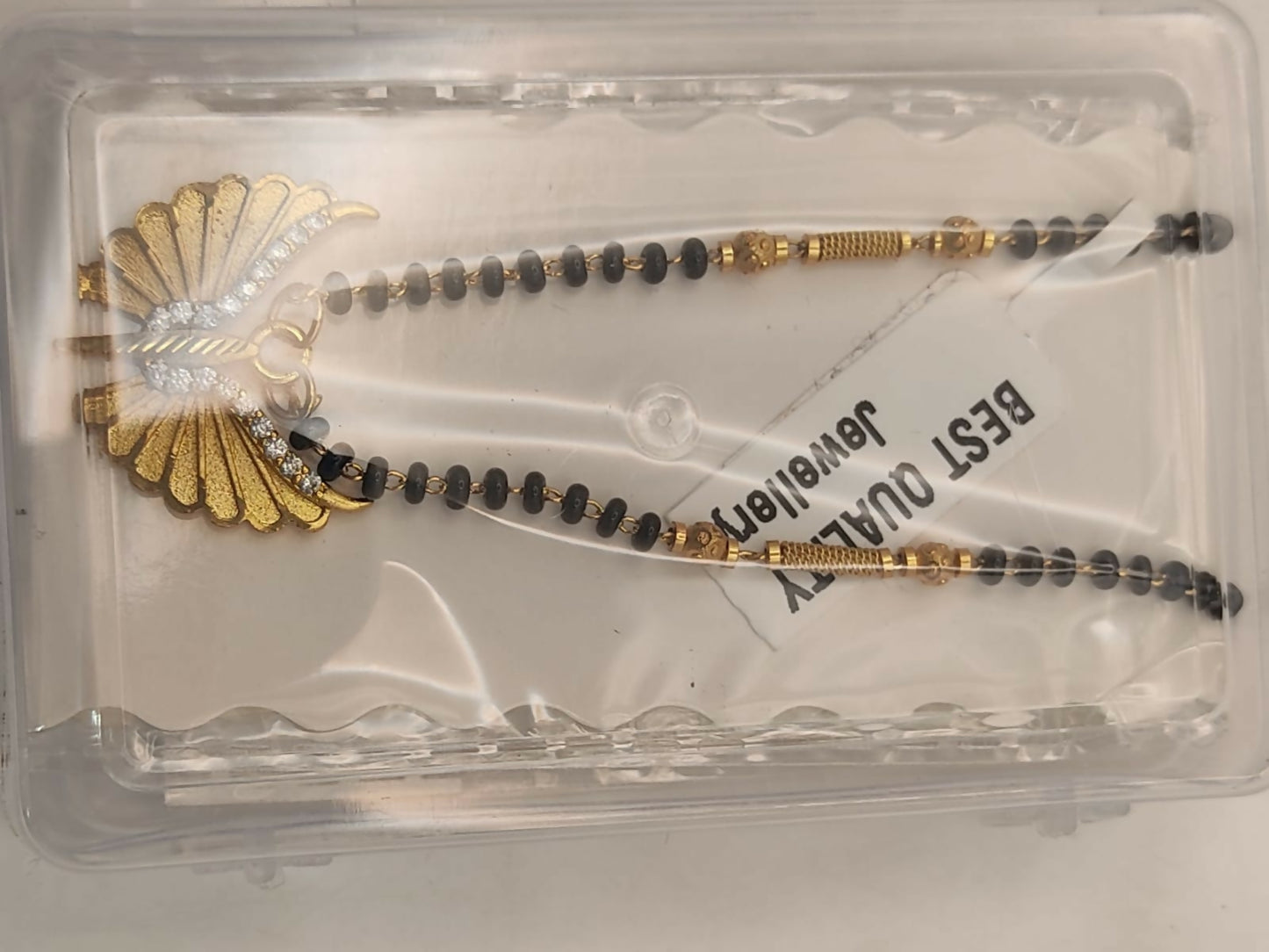 Styled shot of gold-plated butterfly wing mangal sutra worn over white attire