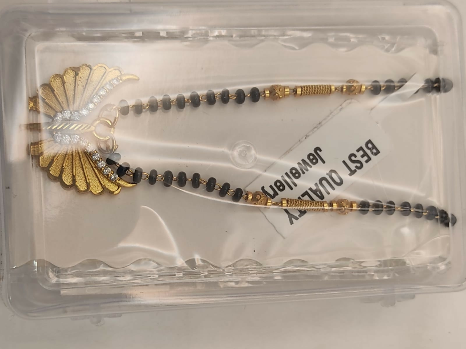 Styled shot of gold-plated butterfly wing mangal sutra worn over white attire