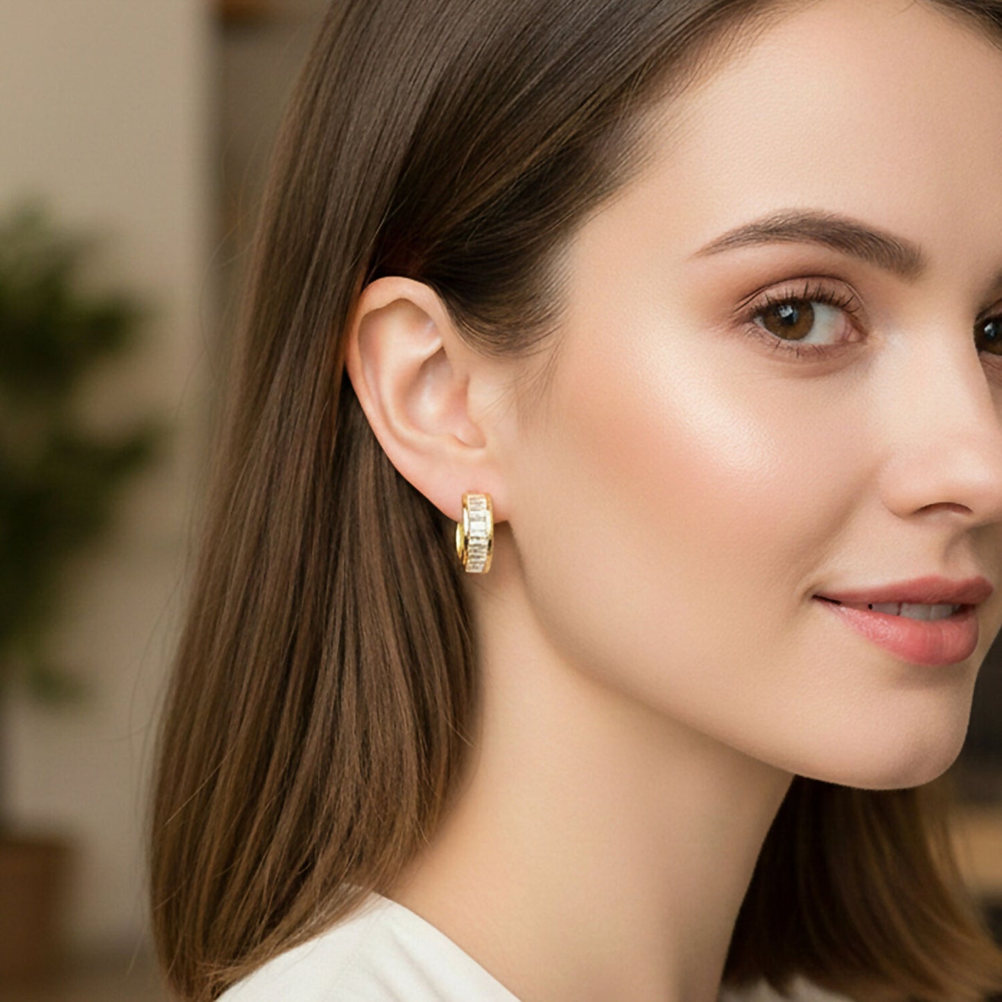 Side view of compact gold hoop earrings studded with cubic zirconia stones