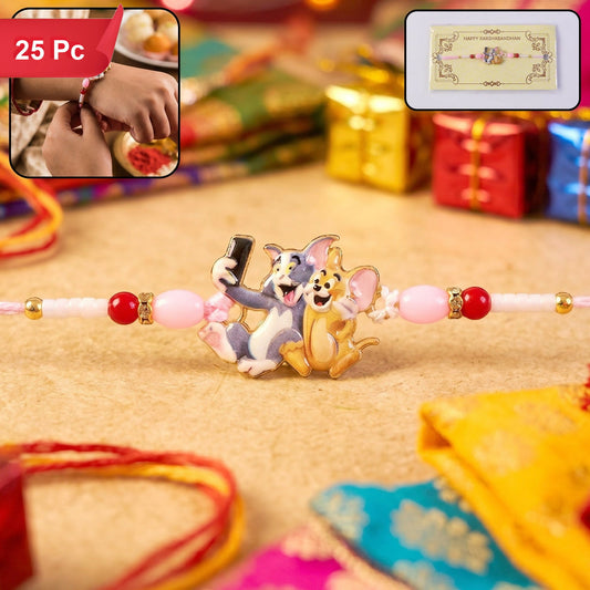A pink and white Rakhi with a Tom and Jerry charm is centered on a light brown surface with blurred festive decorations in