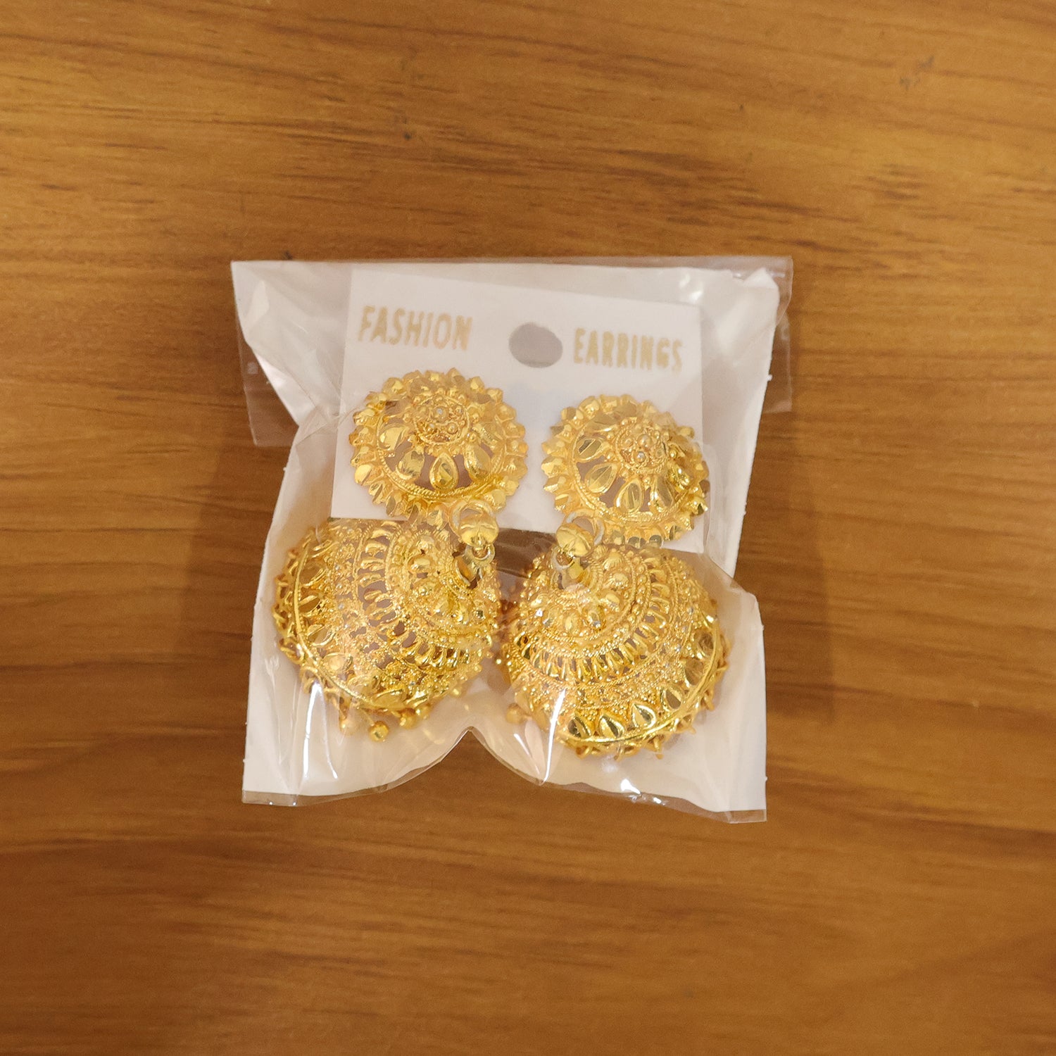 Gold plated jhumka earrings highlighting dome shape and bead details