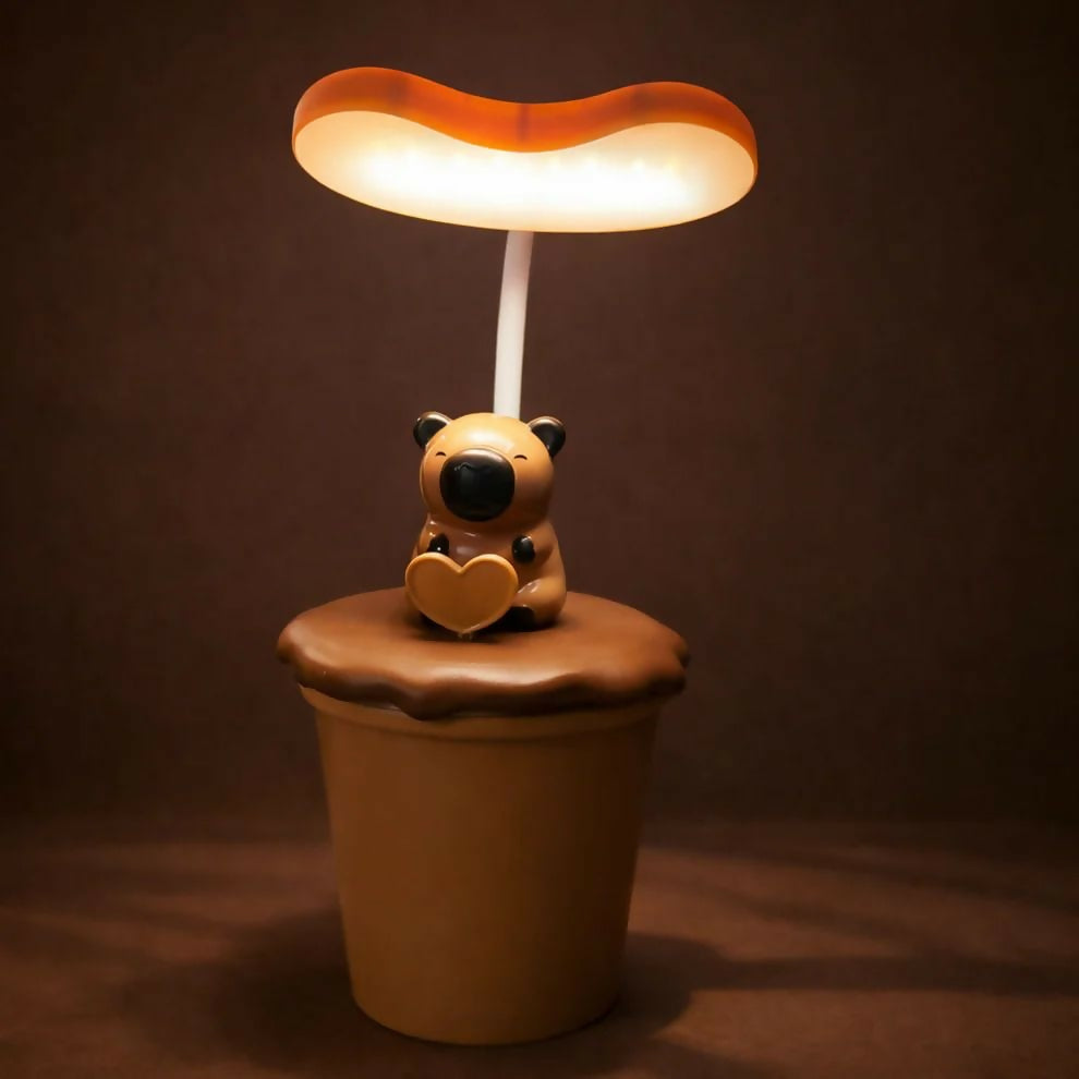 A brown koala desk lamp with a heart glowing on its chest, casting a soft light on a dark background.