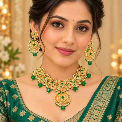 A woman models a gold necklace and earrings with green beads and white stones, complementing her green attire.