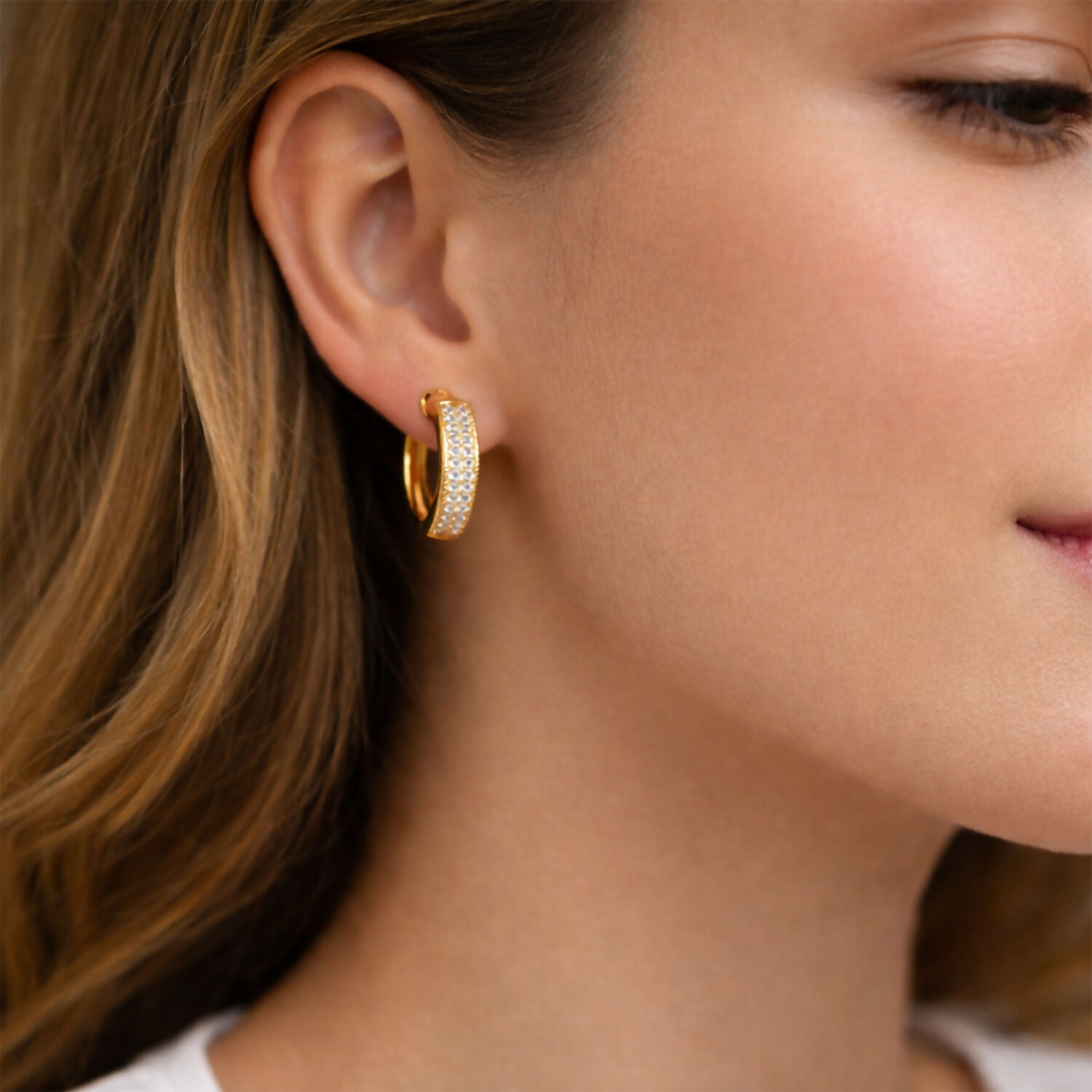 Close-up of gold plated diamond hoop earrings highlighting shiny CZ stones