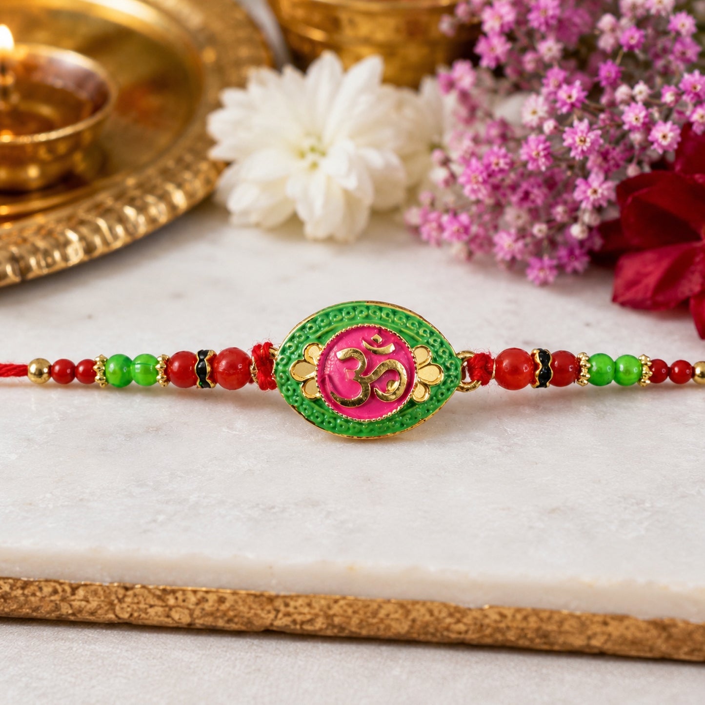 Close-up of OM symbol and bead details on pink green Rakhi thread